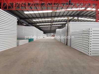 Stacks of flat-pack and folding container house components ready for international shipping from China