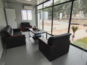 High-end interior of a norman luxury tiny home flat pack with a modern lounge area and large windows in a flat pack tiny house