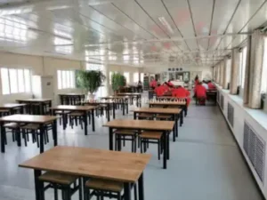 Large dining area within a flat pack housing complex, showing premium finishes for flat pack houses from China